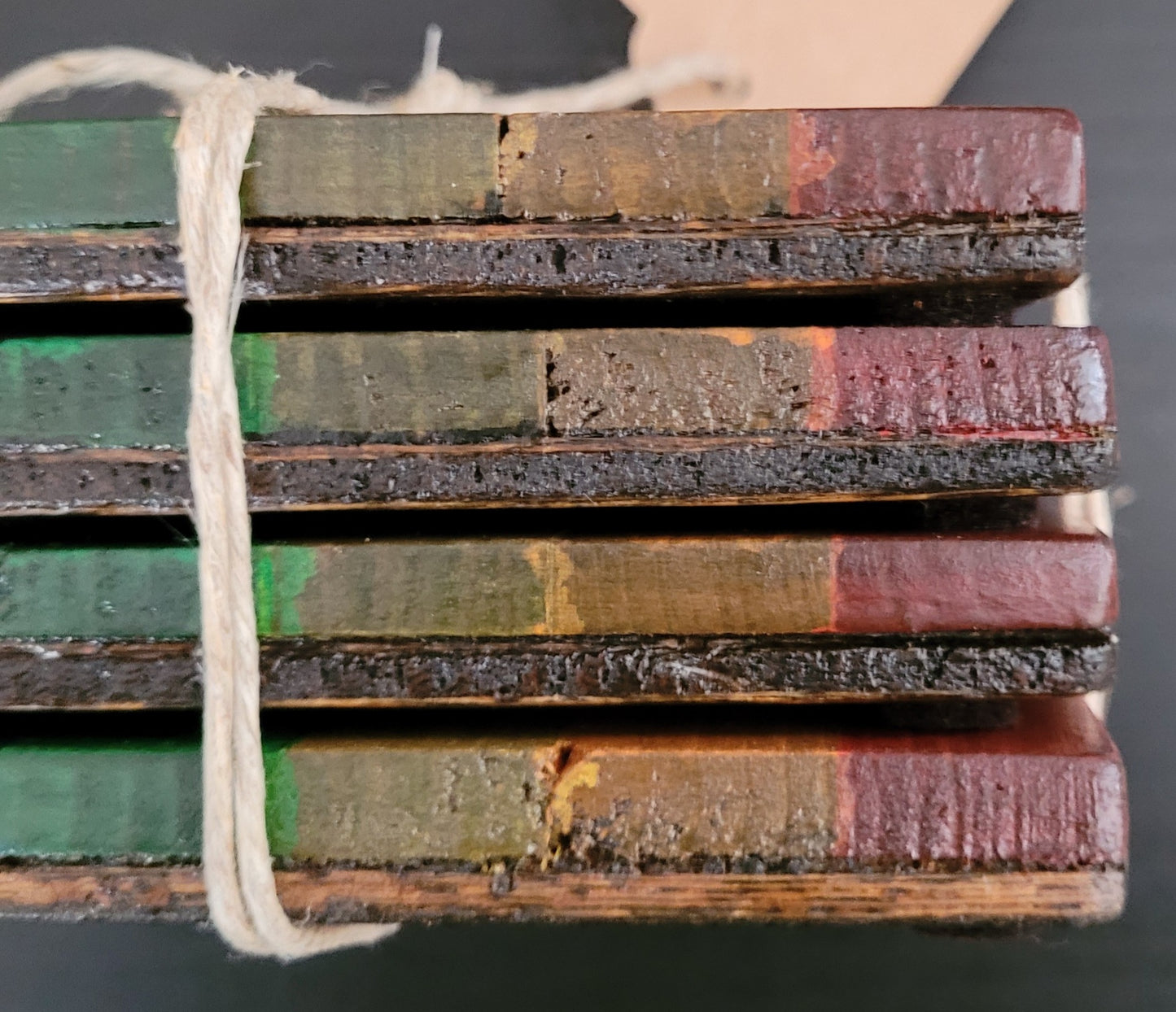 Close up side view of a stack of four coasters.