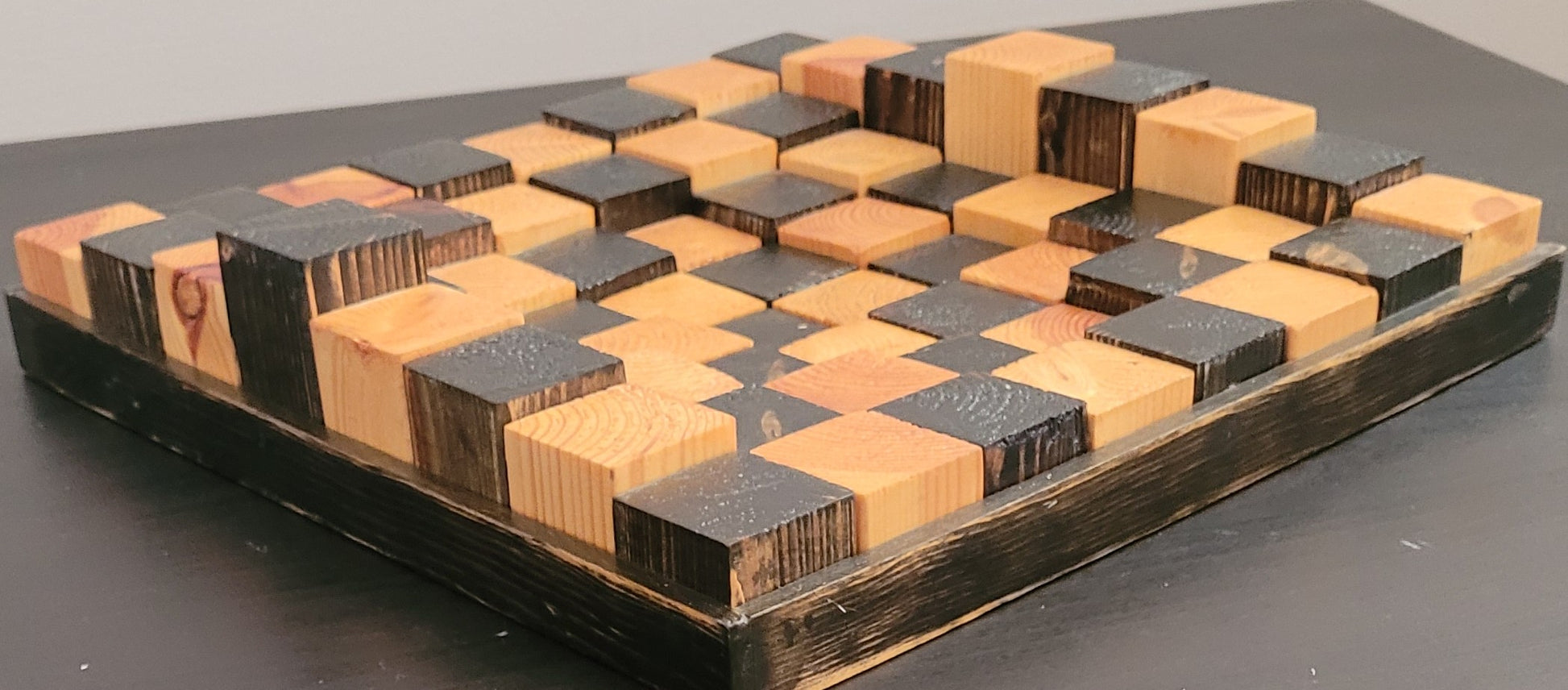 Wooden chess board with geometric pattern on a dark surface