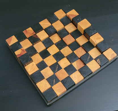 Wooden chessboard with alternating black and brown squares on a dark background