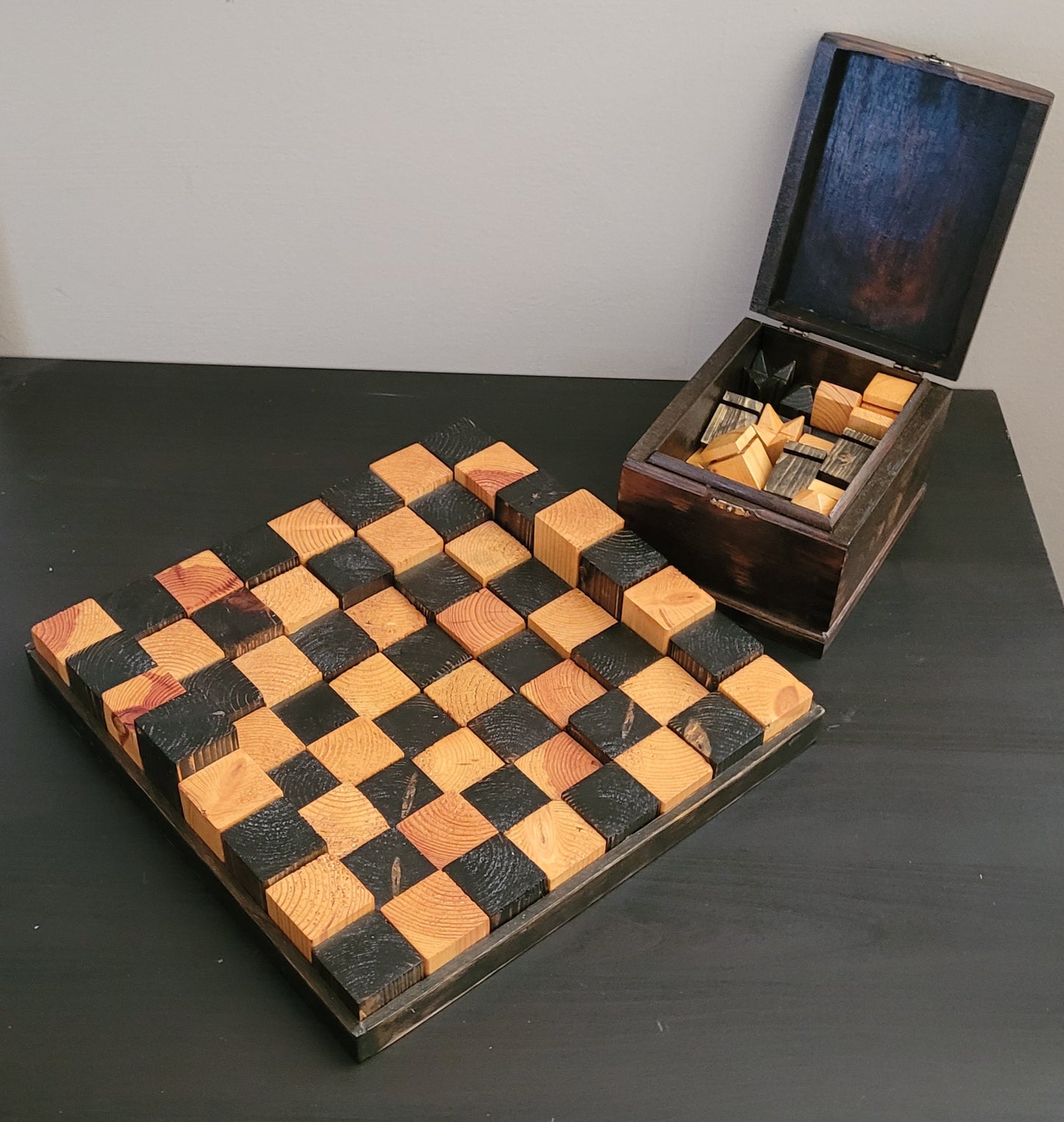 Wooden chessboard with checkers and a wooden box on a dark surface