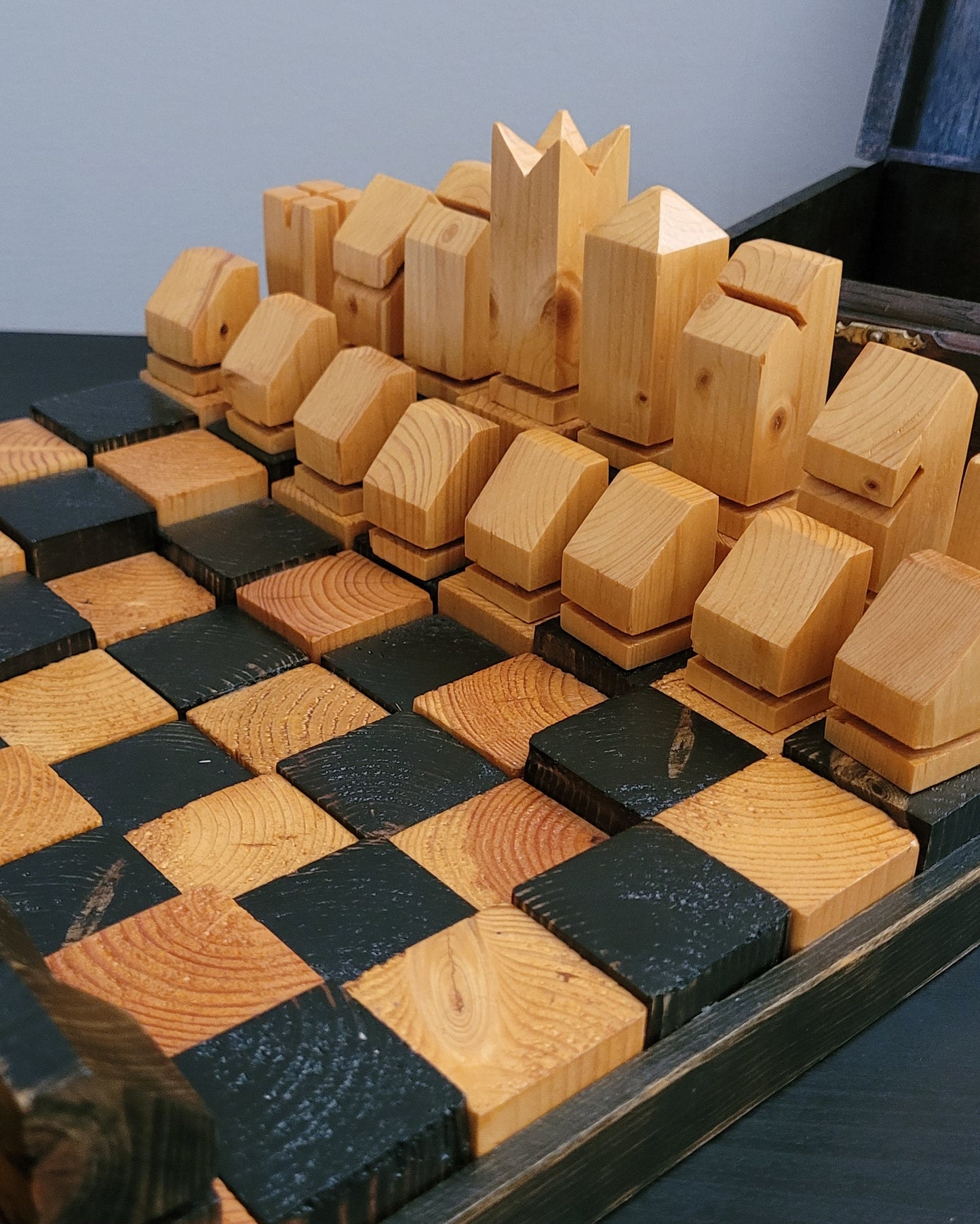 Wooden chess set on a checkered board with a blue background