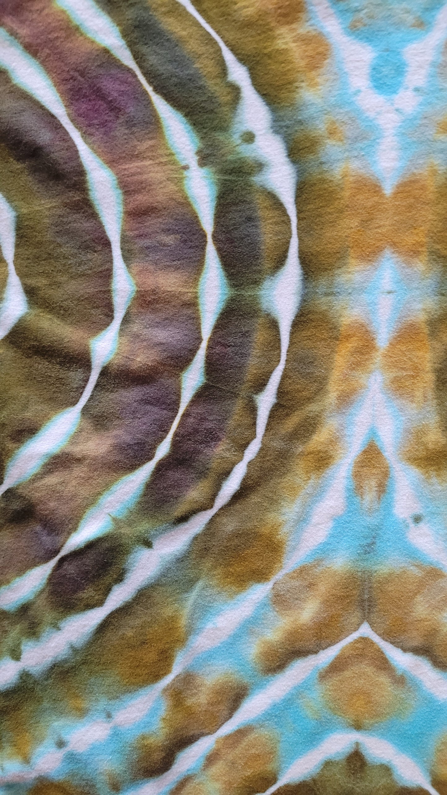 Close-up of tie-dye fabric with brown, blue, and white patterns