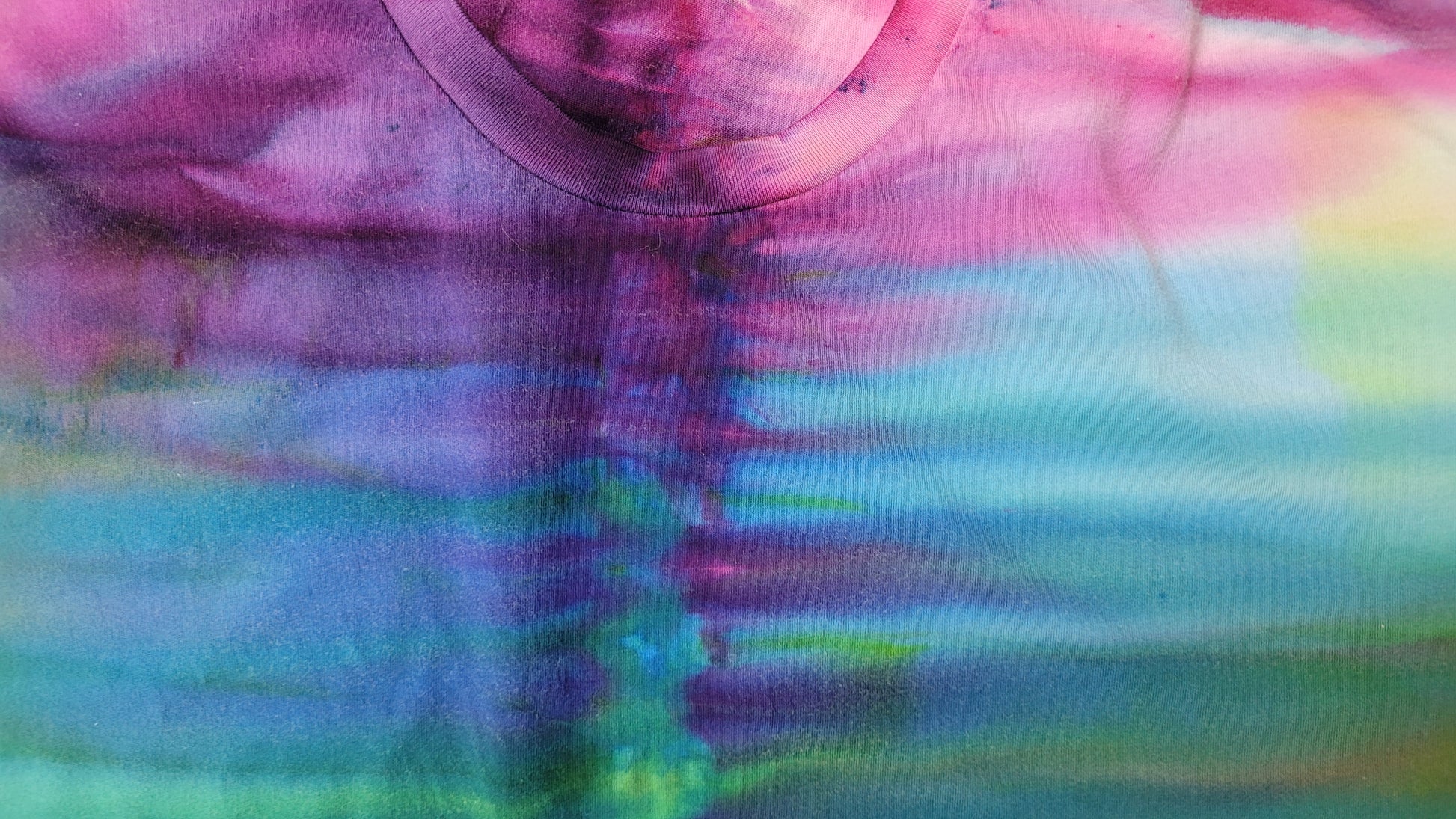 Colorful tie-dye pattern with a circular object in the center.
