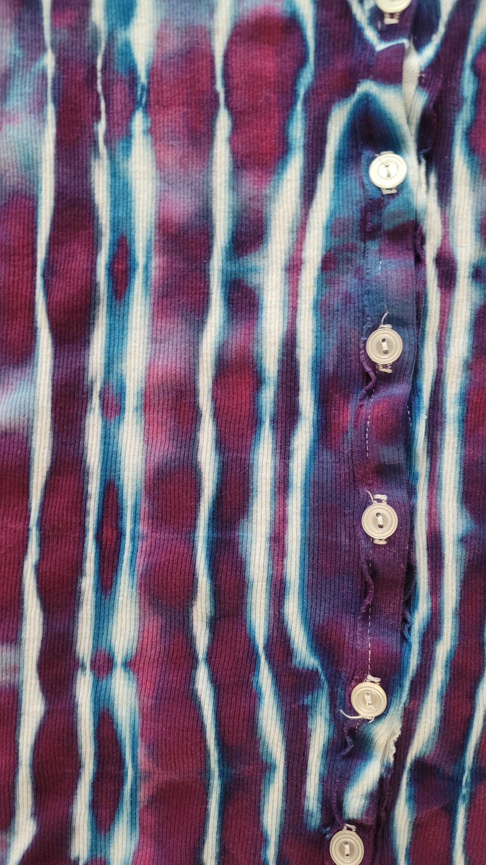 Close-up of a patterned fabric with horizontal stripes in purple, blue, and white.