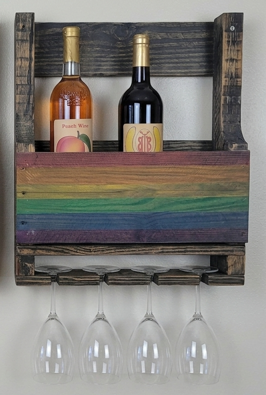 Wooden wine rack with bottles and glasses on a white wall
