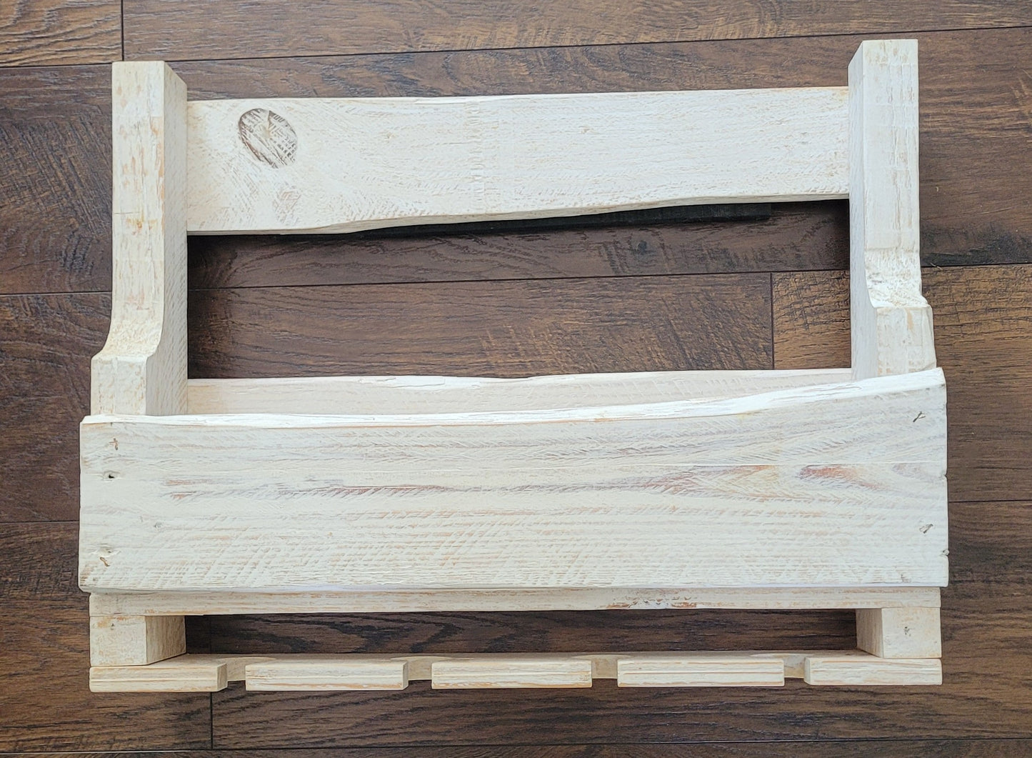 White washed wooden wine rack on a wooden floor
