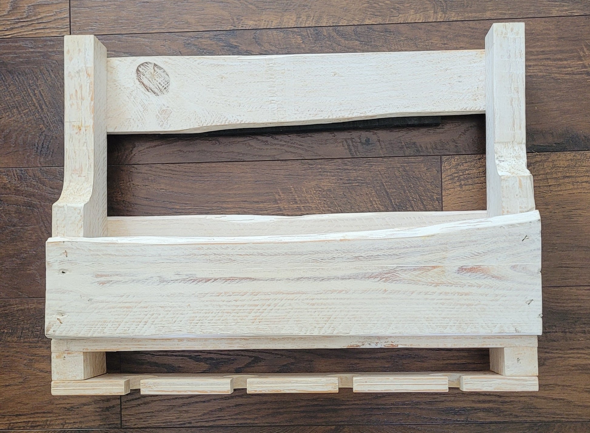 White washed wooden wine rack on a wooden floor