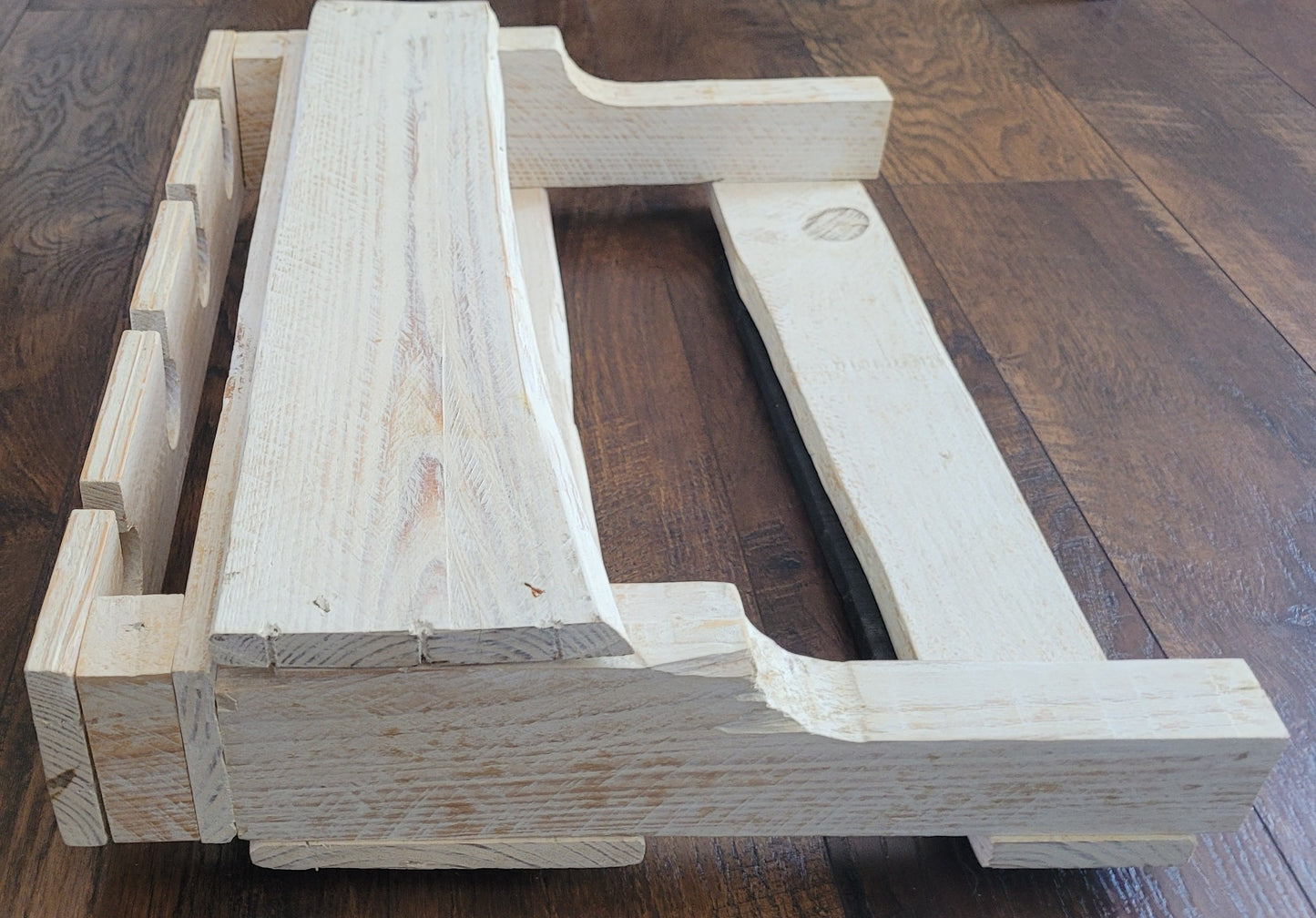 White washed wooden wine rack on a wooden floor