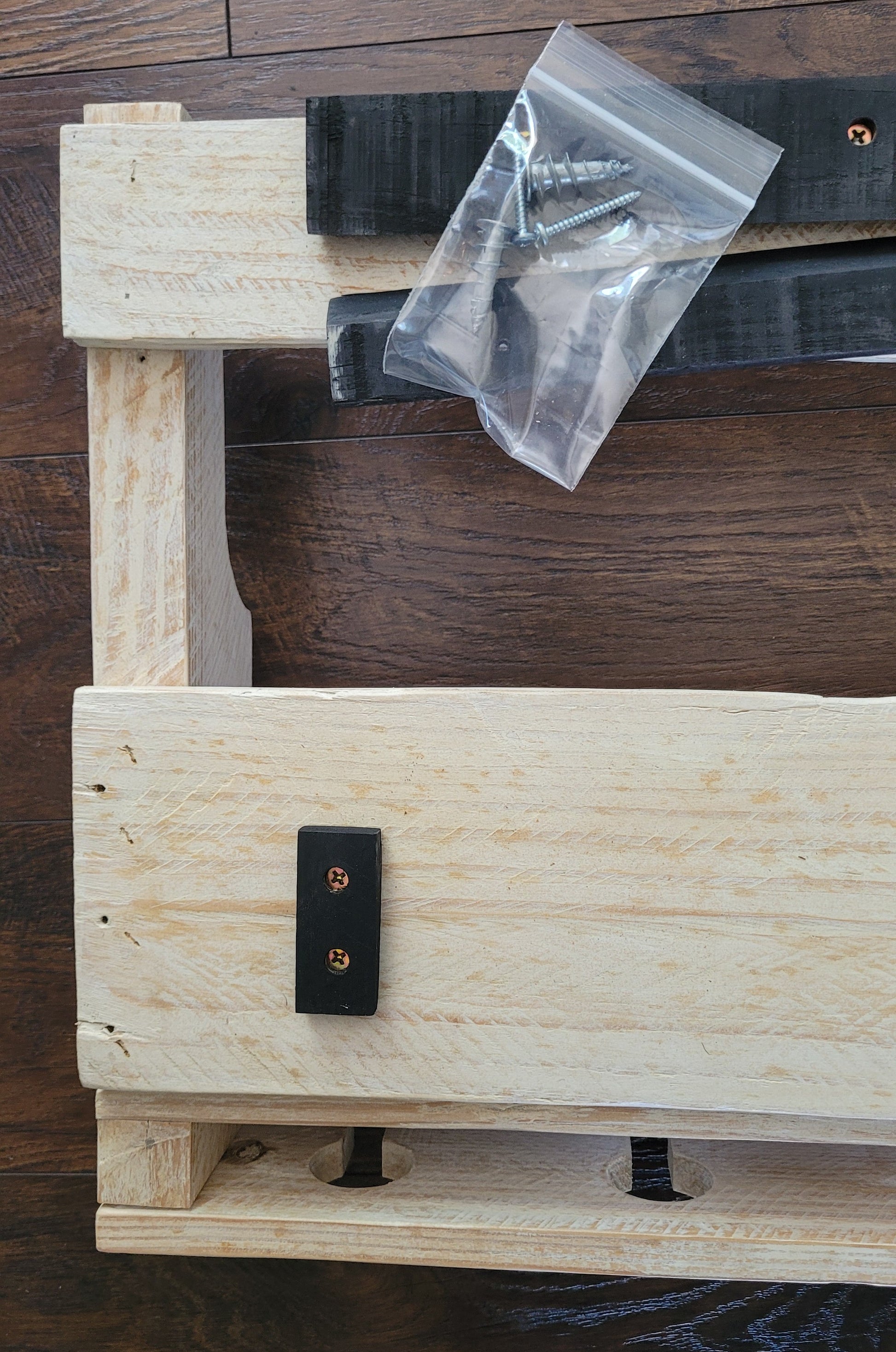 White washed wooden wine rack with mounting bracket on a wooden surface