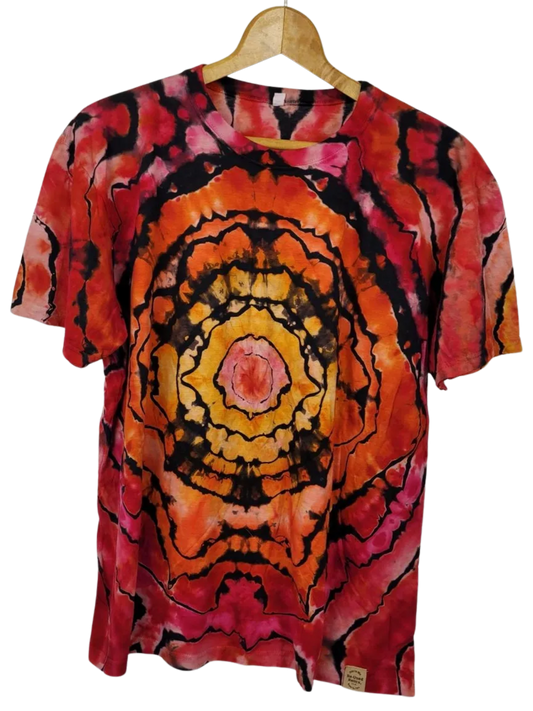 Tie-dye t-shirt with a circular pattern on a hanger against a white background