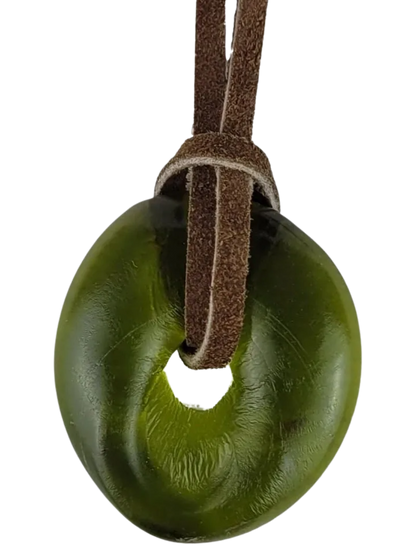 Green donut-shaped object on a brown leather strap against a white background