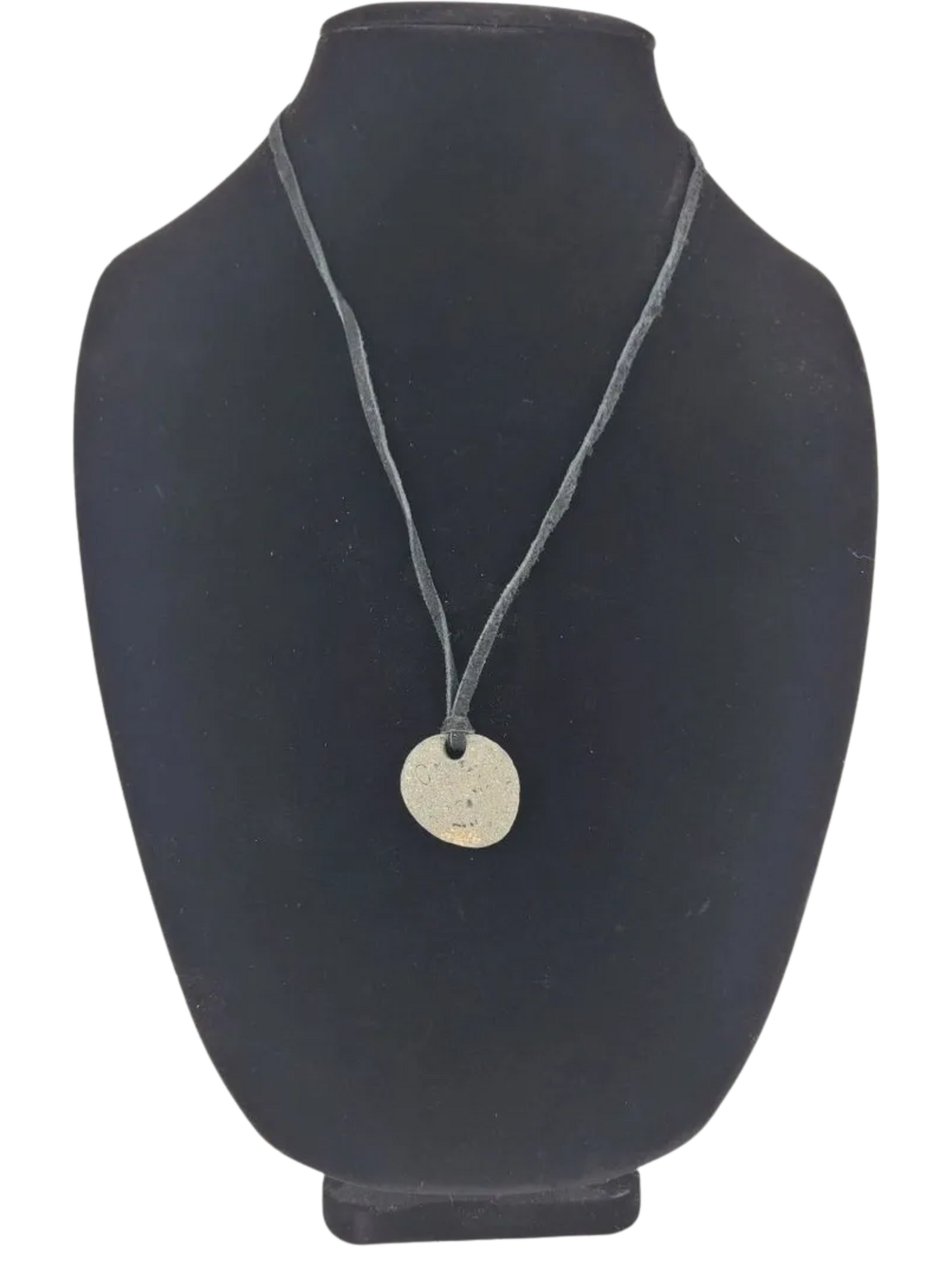 Necklace with a round pendant on a black mannequin bust