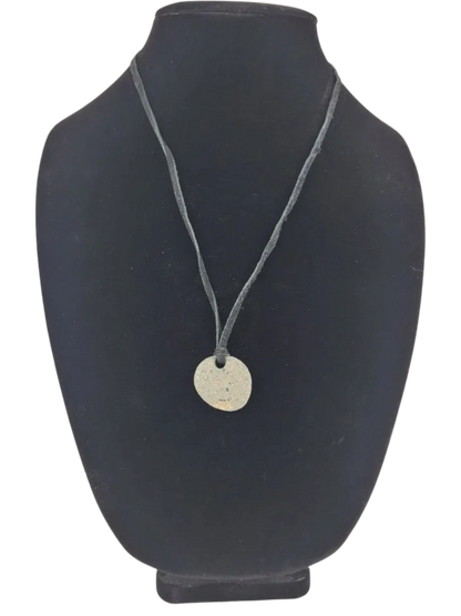 Necklace with a round pendant on a black mannequin bust