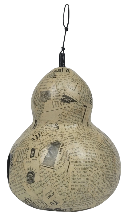 Decorative gourd with newspaper print on a white background