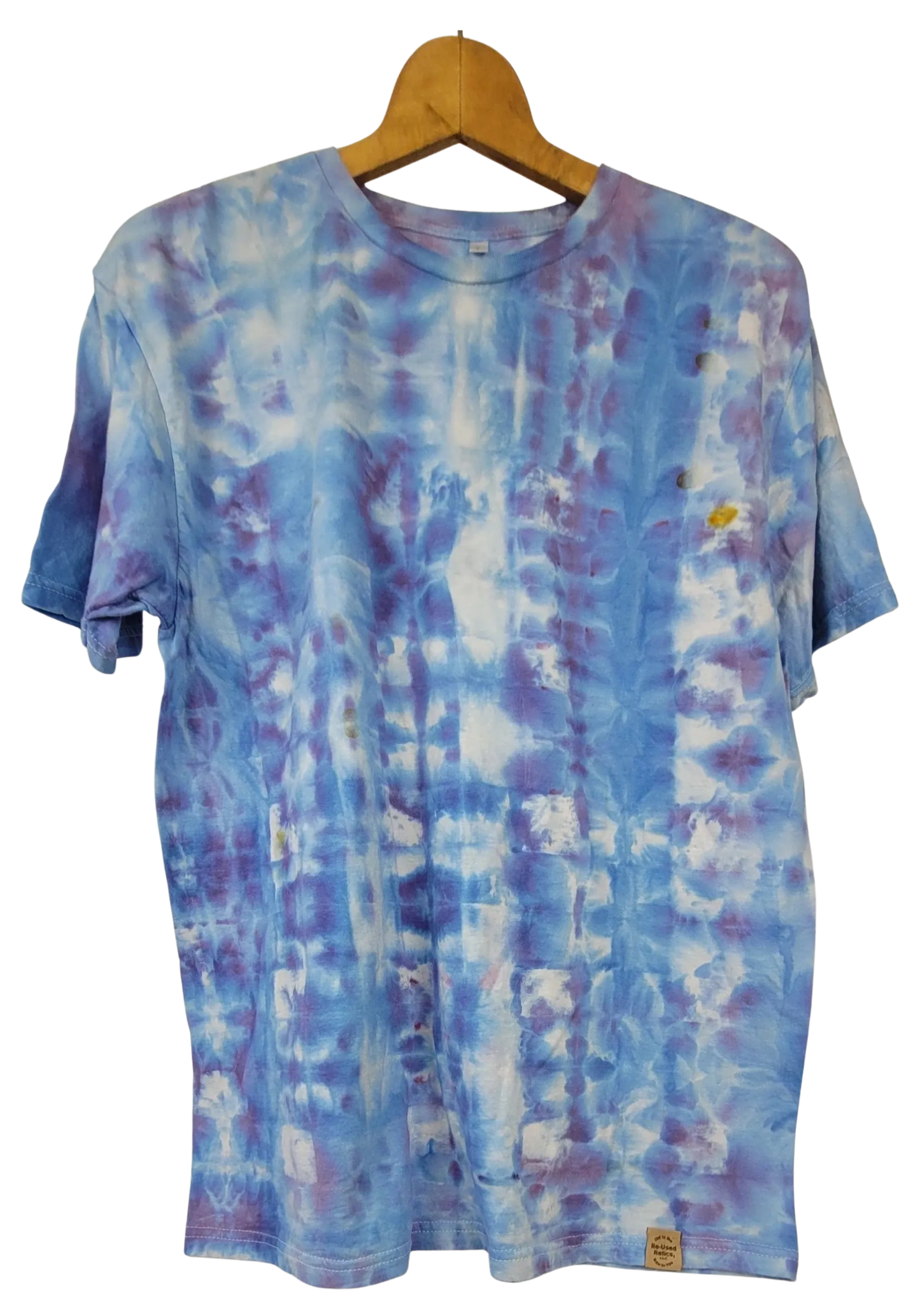Tie-dye t-shirt on a wooden hanger with a white background