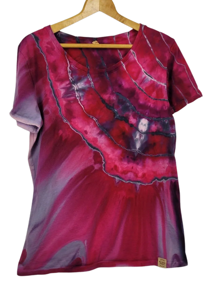 Red and purple tie-dye shirt on a wooden hanger against a white background