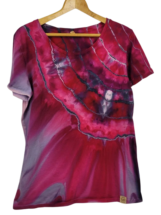 Red and purple tie-dye shirt on a wooden hanger against a white background