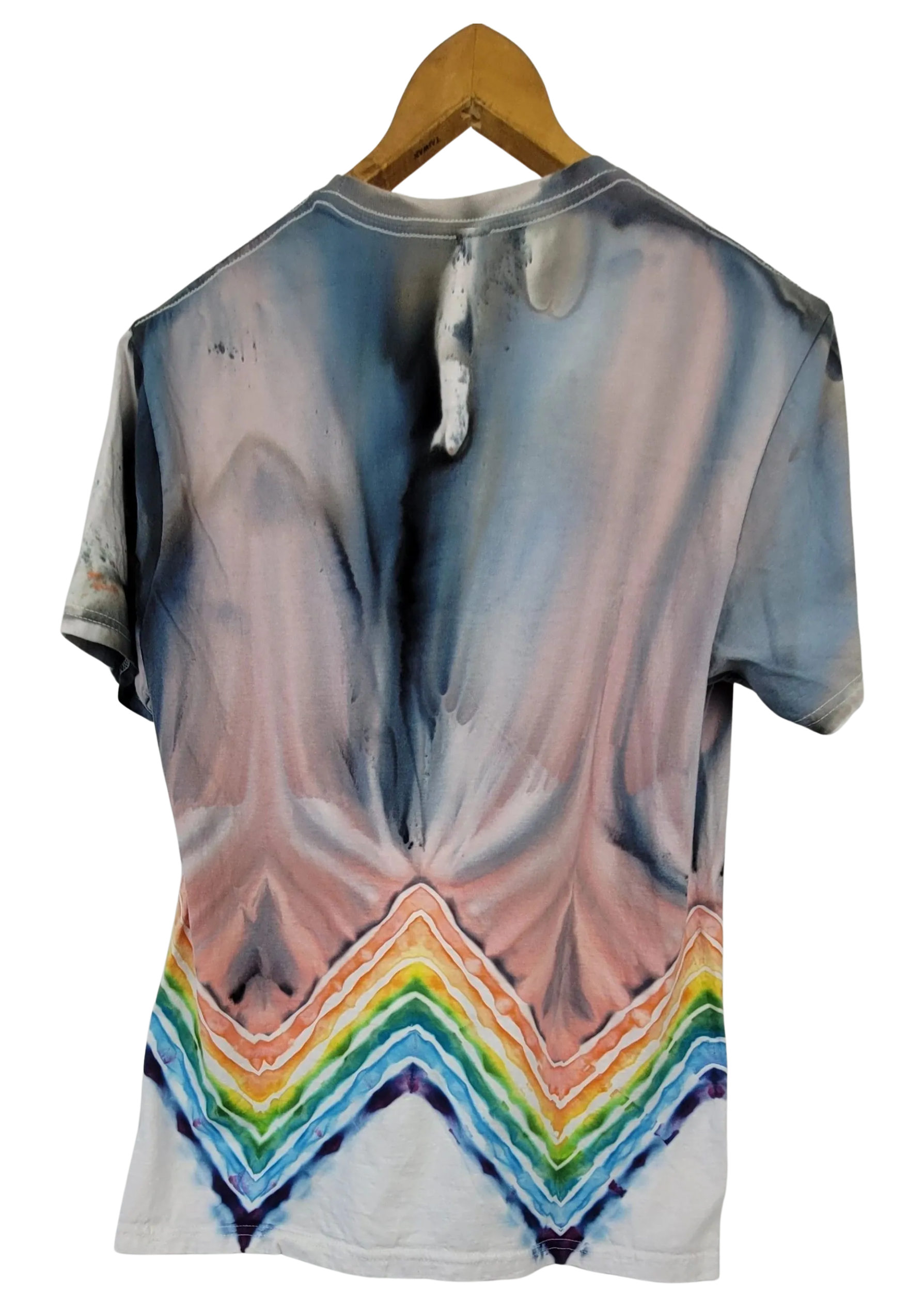 T-shirt with a tie-dye design featuring a rainbow at the bottom, hanging on a wooden hanger.