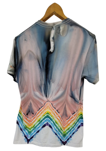 T-shirt with a tie-dye design featuring a rainbow at the bottom, hanging on a wooden hanger.