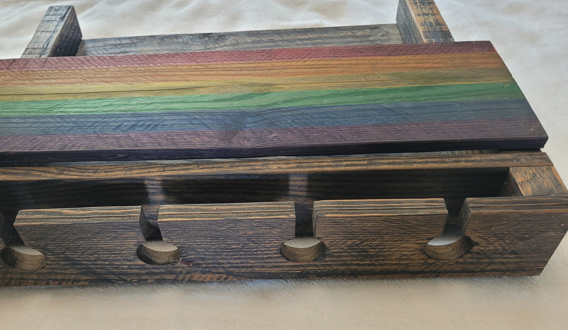 Wooden wine rack with rainbow-colored top and dark brown base